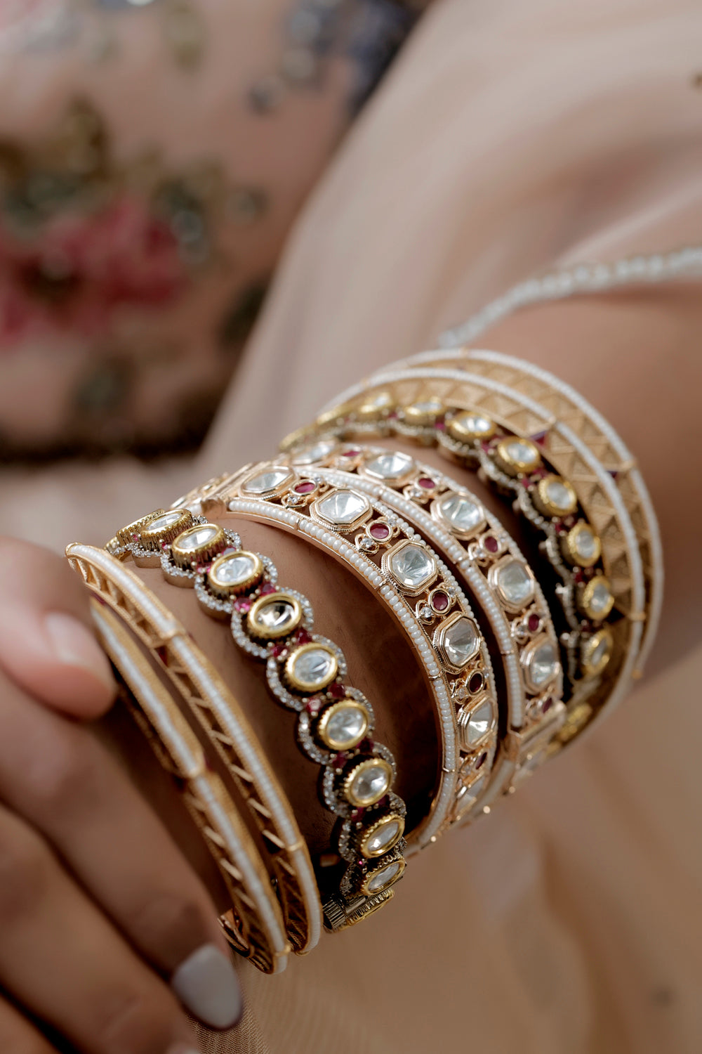 stack of kundan bangles bordered by matte gold 3d bangles