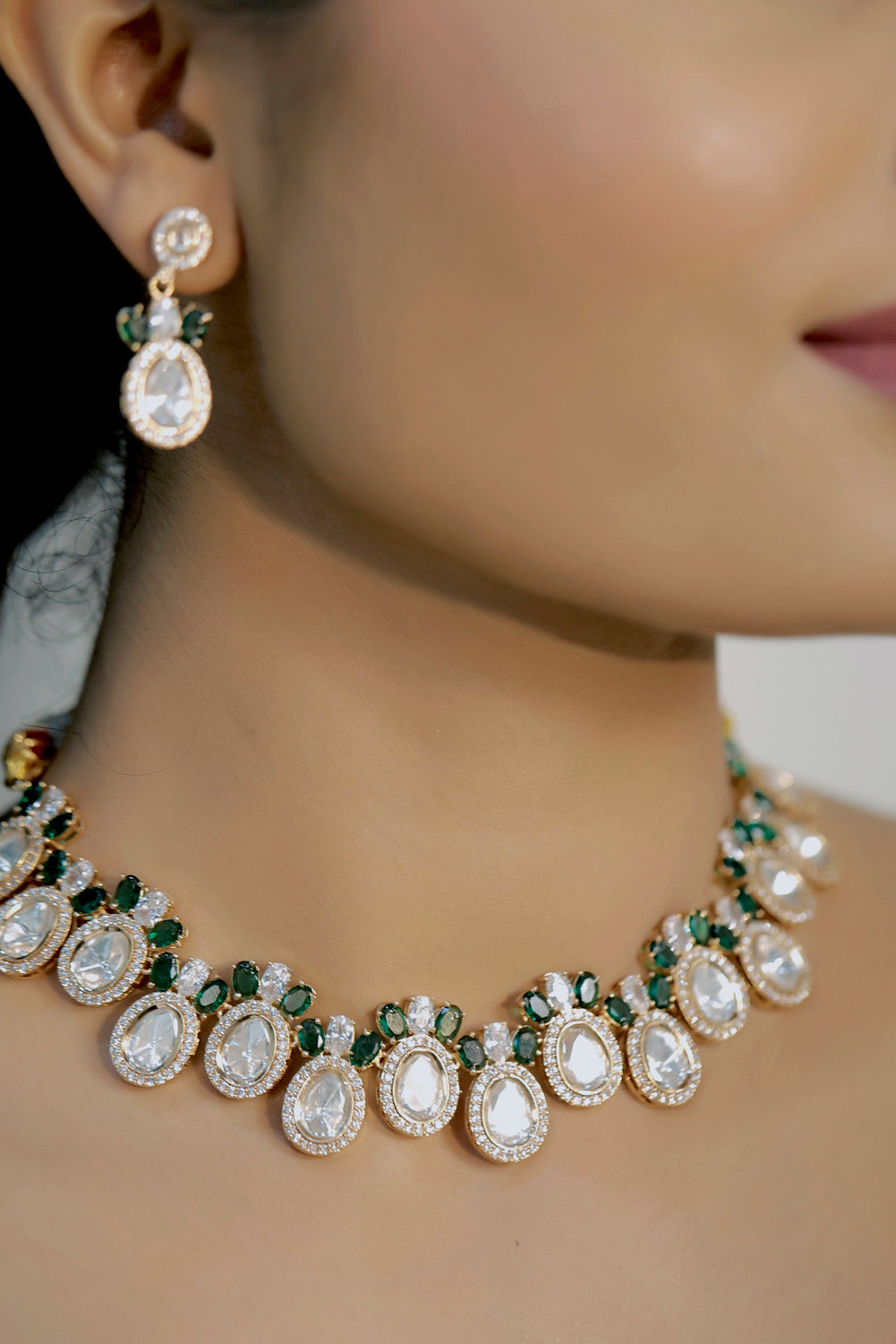 model wearing mossanite tyaani kundan emerald green choker necklace with cubic zirconia and drop earrings set