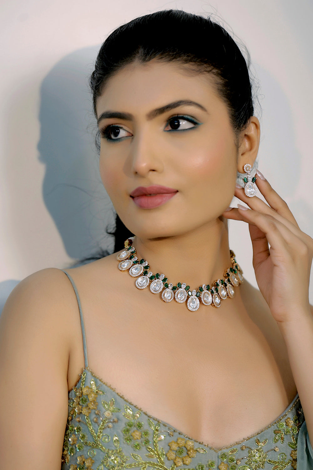 model wearing mossanite tyaani kundan emerald green choker necklace with cubic zirconia and drop earrings set