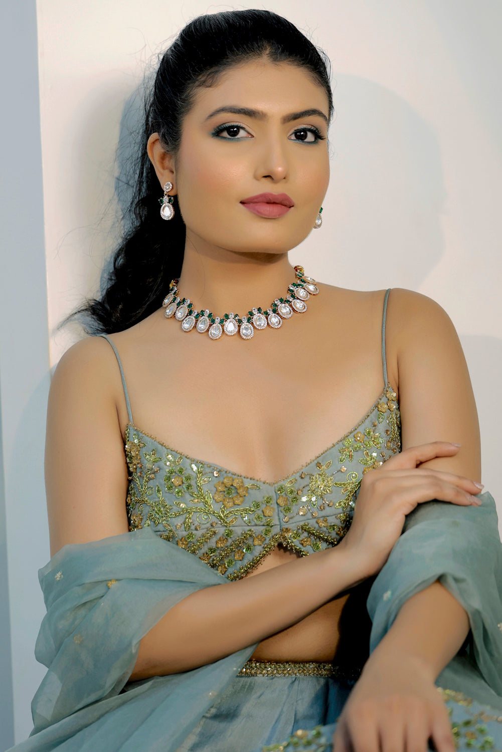 model wearing mossanite tyaani kundan emerald green choker necklace with cubic zirconia and drop earrings set