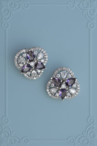 Pair of earrings with purple gemstones on a textured silver background