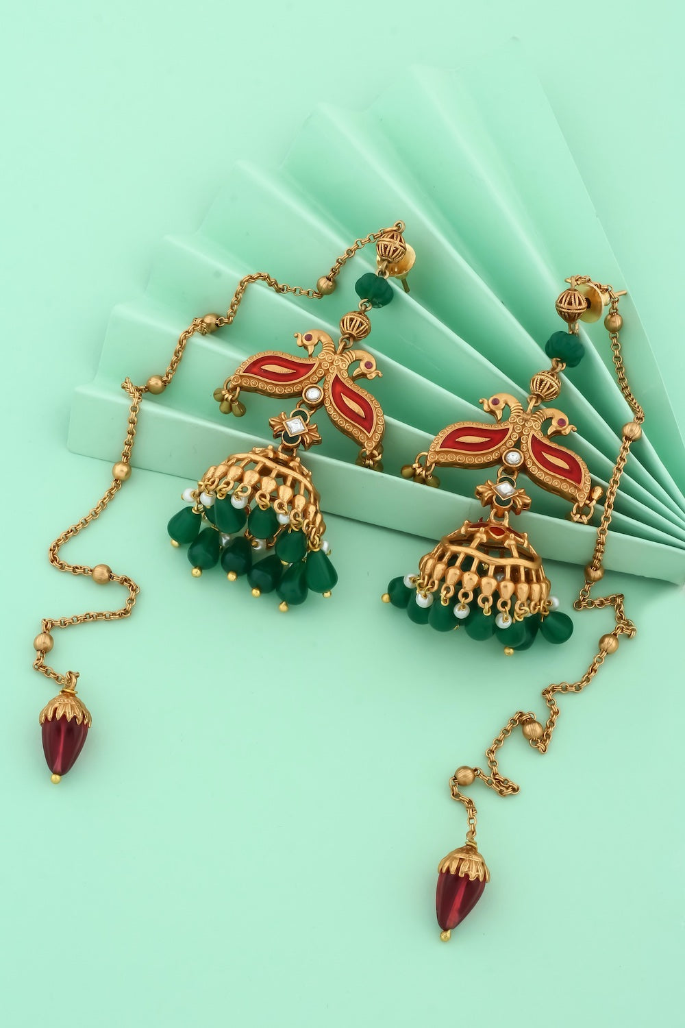 antique gold with meenakari and peacock design and jhumka earrings with green stone danglers